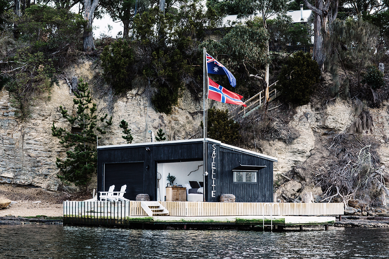 Timber boathouse and jetty above cold clear channel water south of Hobart
