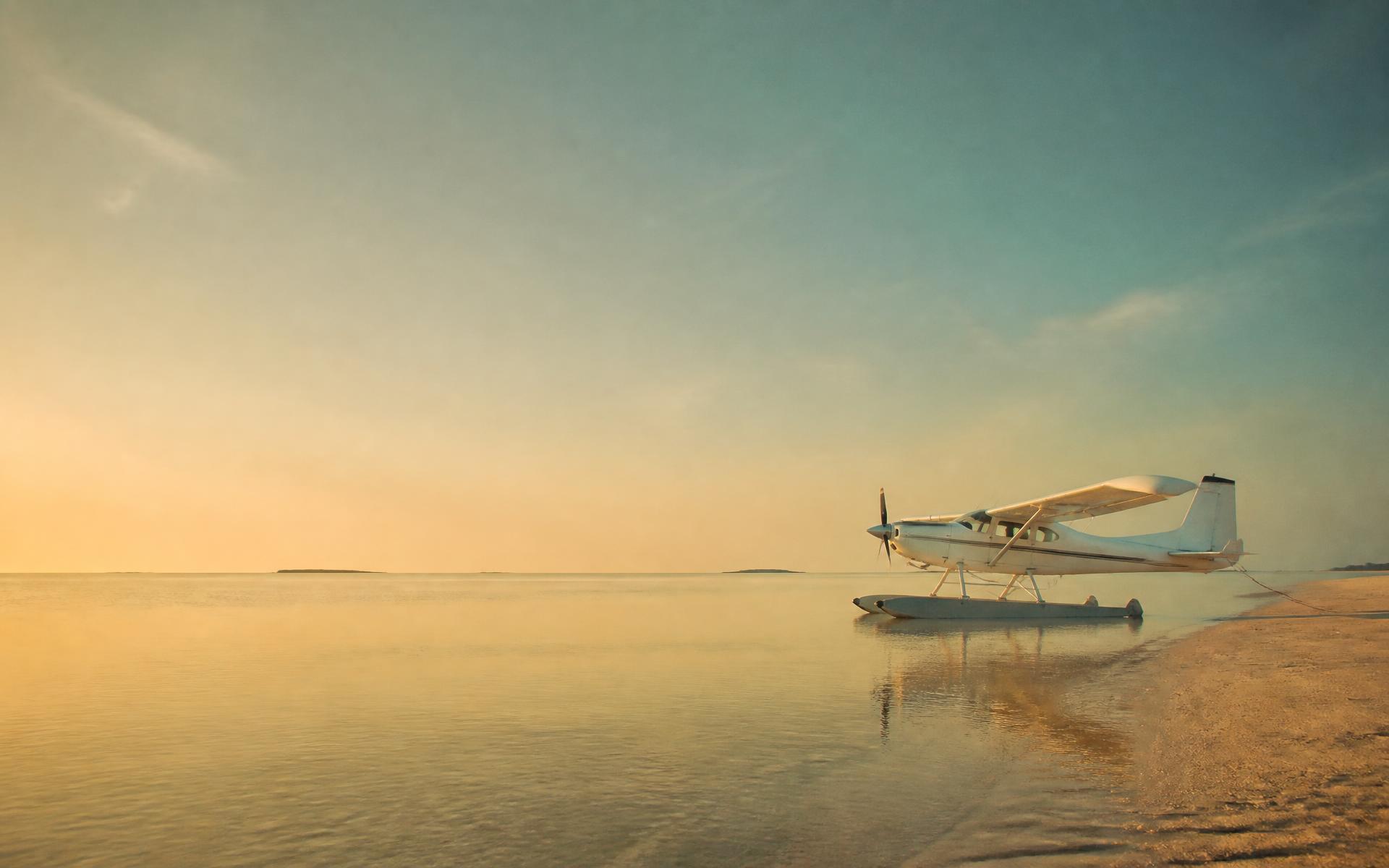 Early light over a wide Australian tidal flat with a moored float plane